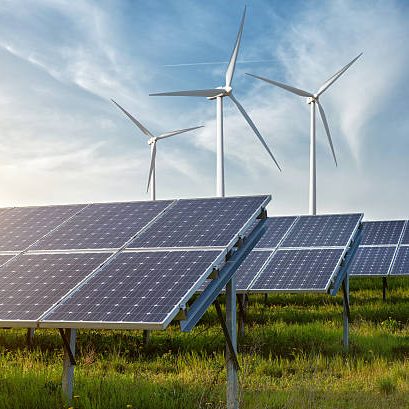 solar panels and wind generators under blue sky on sunset